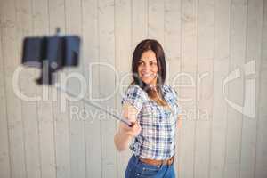 Pretty hipster taking a selfie with stick