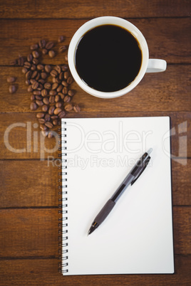 Cup of coffee and notepad with pen