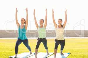 Smiling sporty women doing yoga together