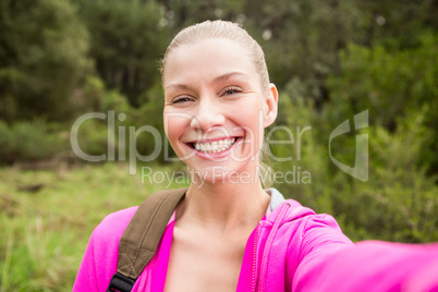 Smiling female hiker taking a selfie