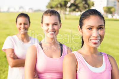 Three smiling women wearing pink for breast cancer