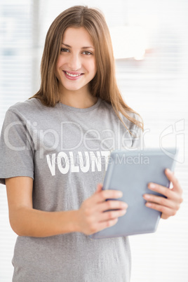 Smiling brunette volunteer with tablet