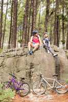 Young happy biker couple sitting on a rock