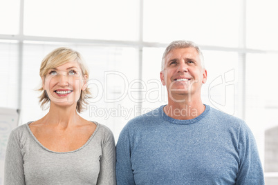 Smiling business colleagues looking above Smiling business colleagues looking above
