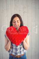 Pretty hipster holding heart pillow