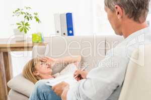 Therapist listening to female patient and taking notes