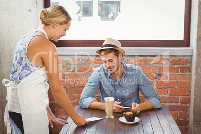 Blonde waitress showing bill to handsome hipster