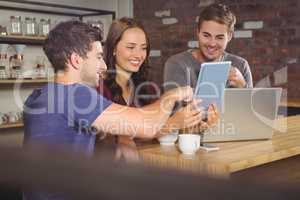Smiling friends pointing and looking at tablet computer