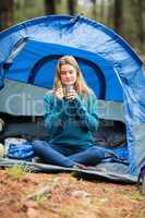Portrait of a young pretty hiker sitting in a tent