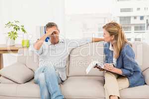 Concerned therapist talking with male patient