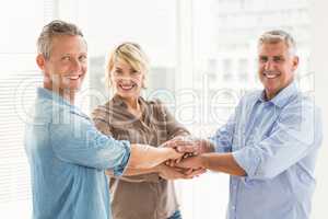 Smiling business colleagues stacking hands