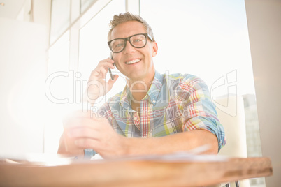 Smiling casual designer having a phone call