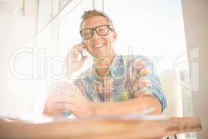 Smiling casual designer having a phone call