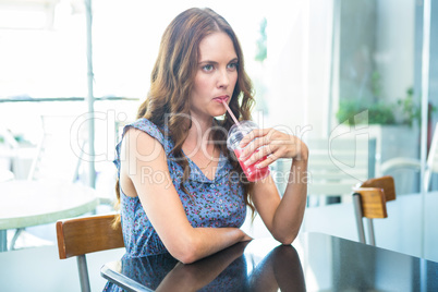 Pretty brunette sipping on a smoothie