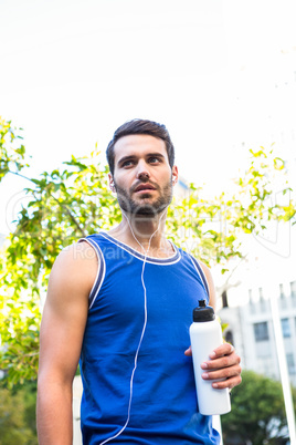 Handsome athlete holding bottle