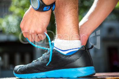 Athlete tying his shoes on a sunny day