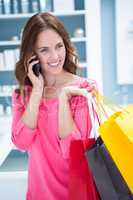 Pretty woman talking on phone while shopping