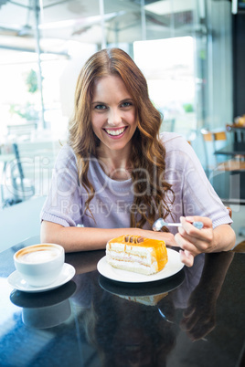 Pretty brunette enjoying a cake