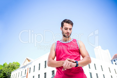 Handsome athlete adjusting his stopwatch