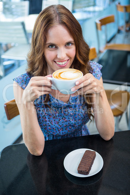 Pretty brunette having coffee and cake
