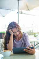 Woman using tablet on cafe terrace