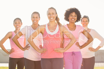 Smiling women wearing pink for breast cancer and posing