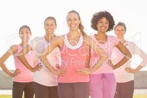 Smiling women wearing pink for breast cancer and posing