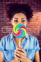 Portrait of a beautiful woman holding a giant lollipop