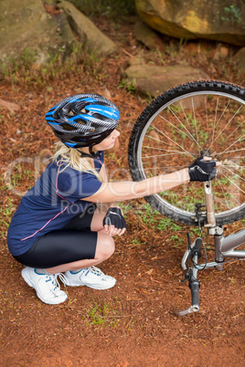 Athletic blonde checking her mountain bike