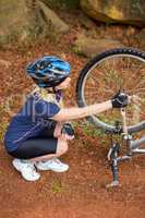Athletic blonde checking her mountain bike