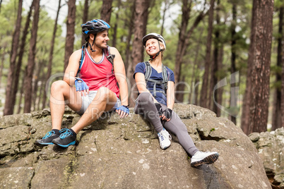 Young happy biker couple sitting on a rock