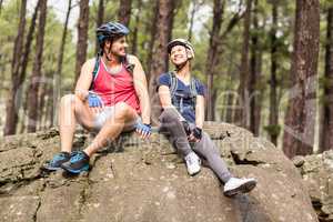 Young happy biker couple sitting on a rock