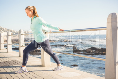 Fit blonde stretching on railing