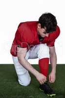 American football player tying his shoelaces