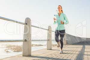 Focused fit blonde jogging at promenade