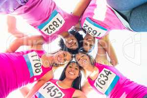 Five smiling runners supporting breast cancer marathon