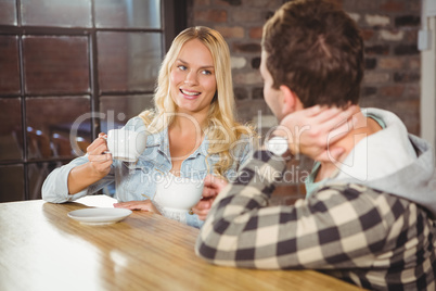 Smiling blonde enjoying coffee with friend