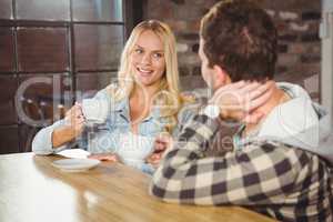 Smiling blonde enjoying coffee with friend