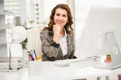 Smiling casual businesswoman working at desk