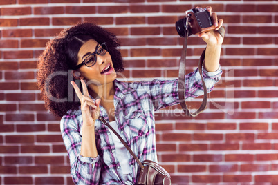 Attractive hipster taking selfies with camera