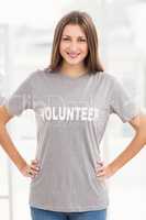 Smiling brunette volunteer with hands on hips