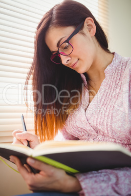 Pretty brunette studying beside window