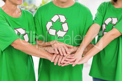 Eco-minded colleagues putting hands together