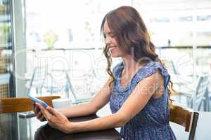 Woman having coffee and using her tablet