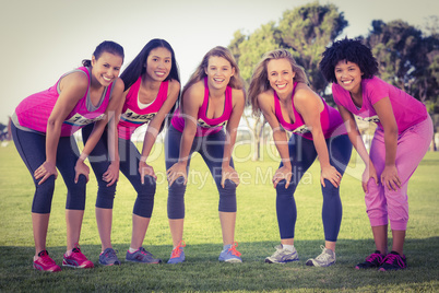 Five smiling runners supporting breast cancer marathon