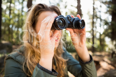 Blonde hiker looking through binoculars