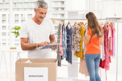 Casual businessman with donation box and tablet