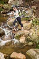 Profile view of a fit woman lifting her bike