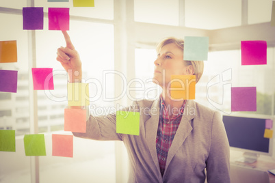 Casual businesswoman reading sticky notes