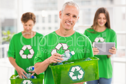 Smiling eco-minded man holding recycling box